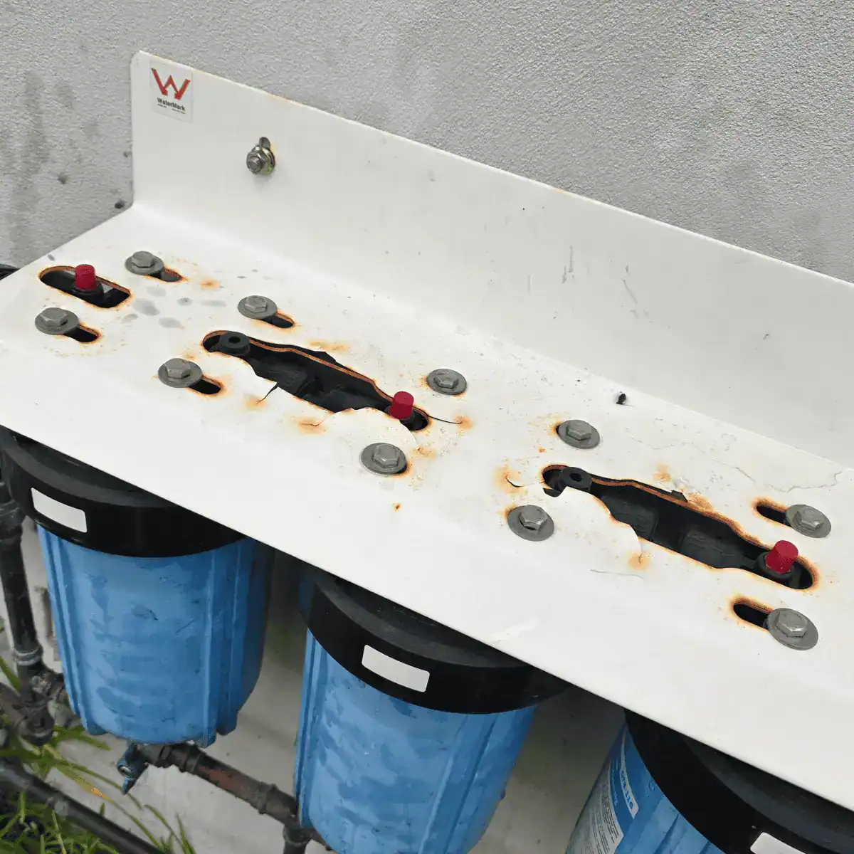 Unprotected water filtration system showing exposed fittings and outdoor wear