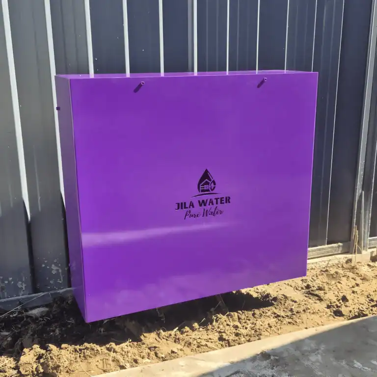 Custom purple Jila Water whole home water filtration system installed against a Brisbane fence